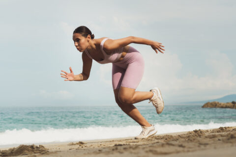 Woman doing running drills on a beach