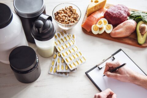 Athlete planning their sports nutrition with supplements and whole foods on a table