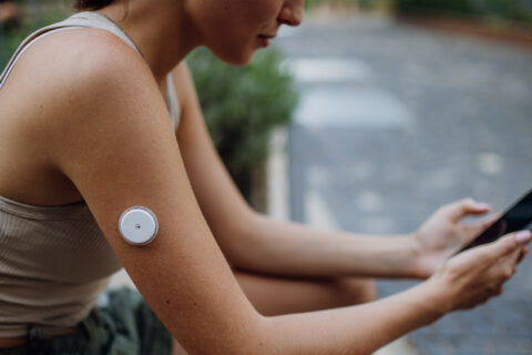 Woman wearing a continuous lactate monitor on her arm.