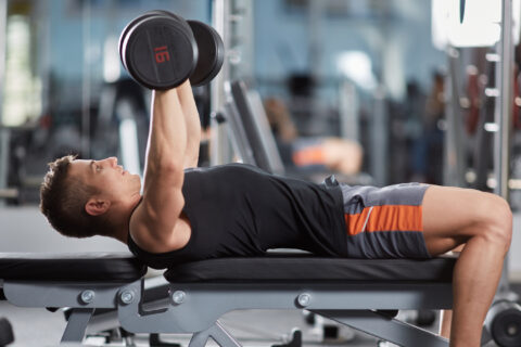 Man doing upper body exercise on a workout bench.