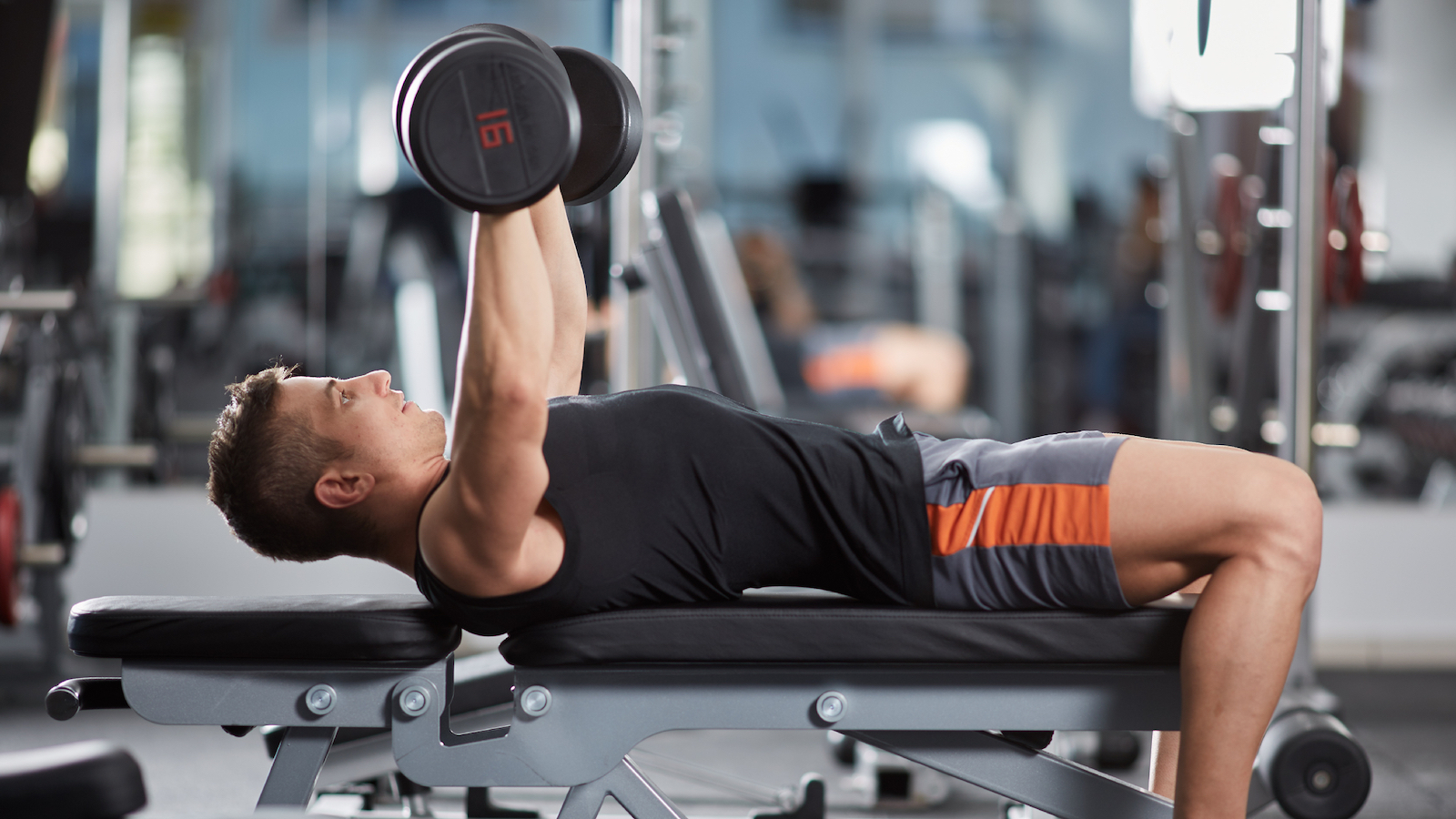 Man doing upper body exercise on a workout bench.