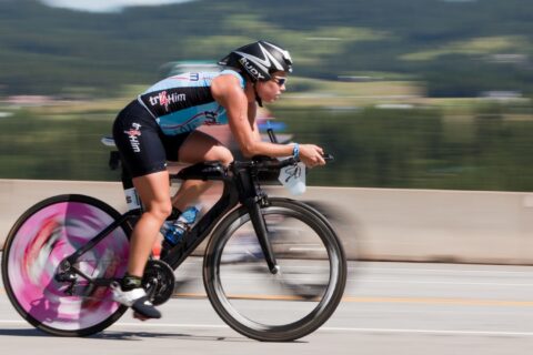 Blurred image of a woman riding a bike with aerobars.