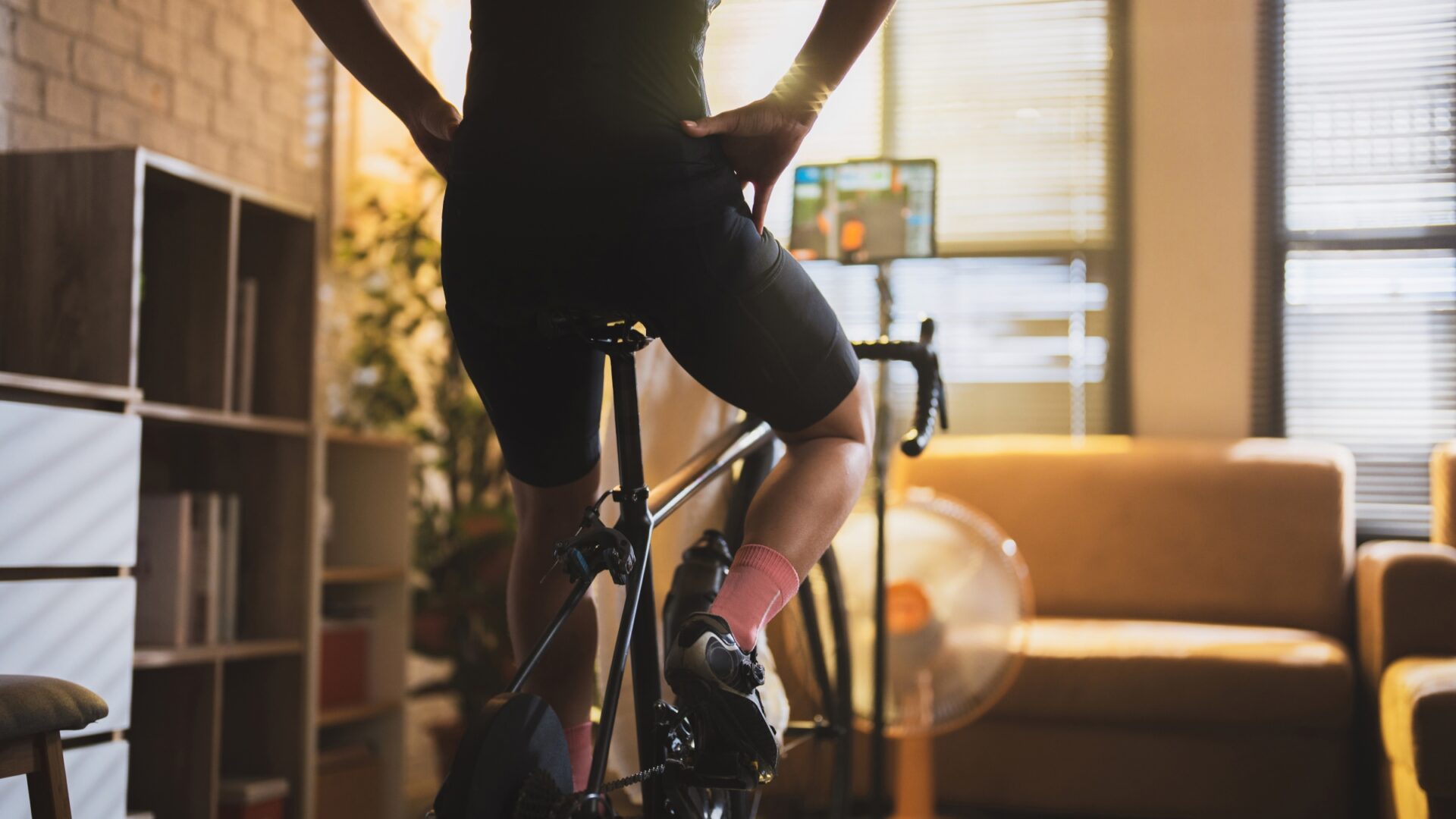 Rear shot of a cyclist resting upright during an indoor training ride