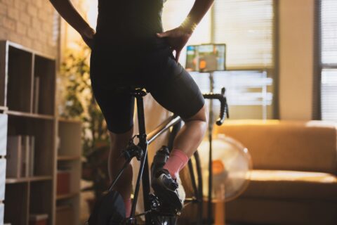 Rear shot of a cyclist resting upright during an indoor training ride