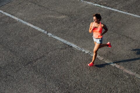 Woman running across asphalt