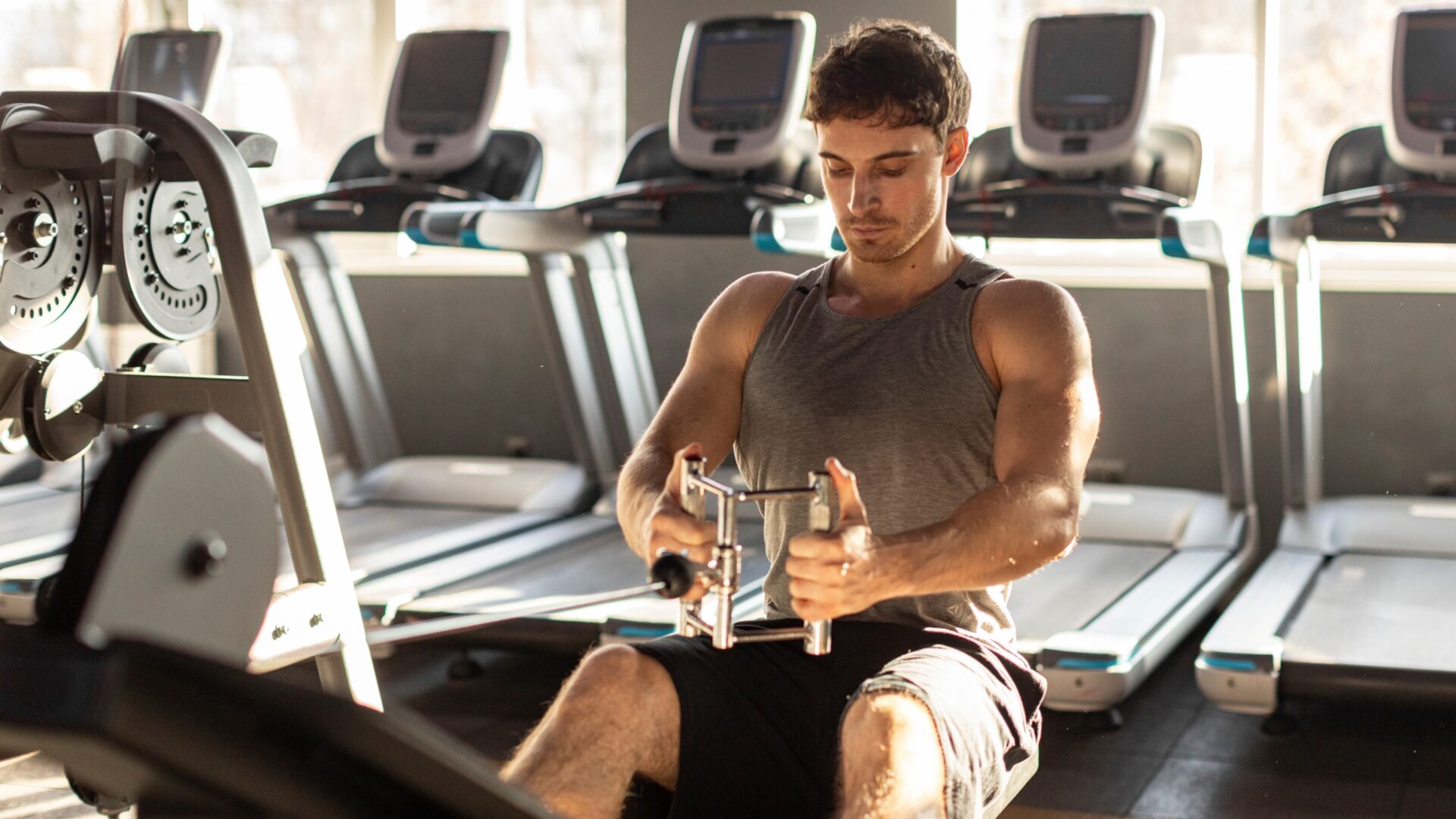 Man performing a seated cable row in a gym