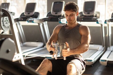 Man performing a seated cable row in a gym