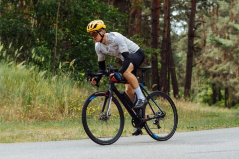 A man sprinting out of the saddle of his road bike